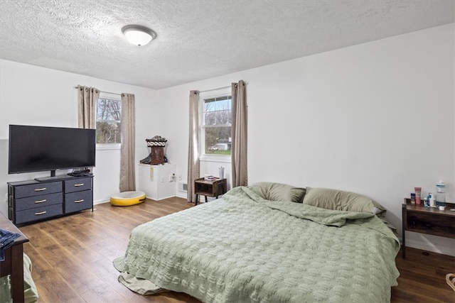 bedroom featuring dark hardwood / wood-style flooring and a textured ceiling