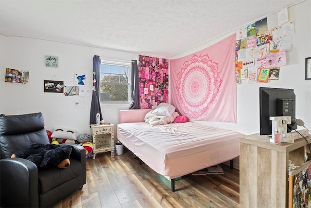 bedroom featuring hardwood / wood-style flooring and a textured ceiling