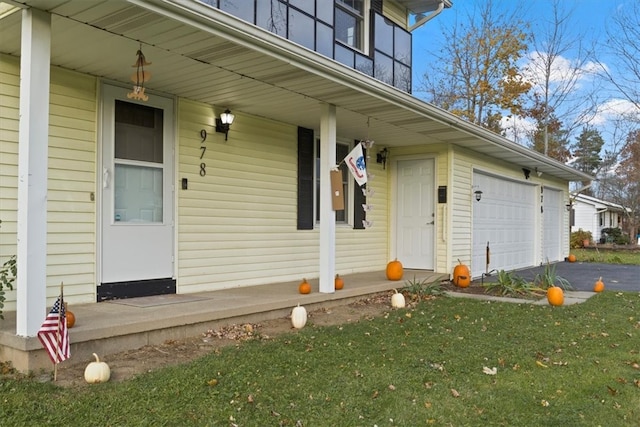 view of exterior entry featuring a porch and a garage