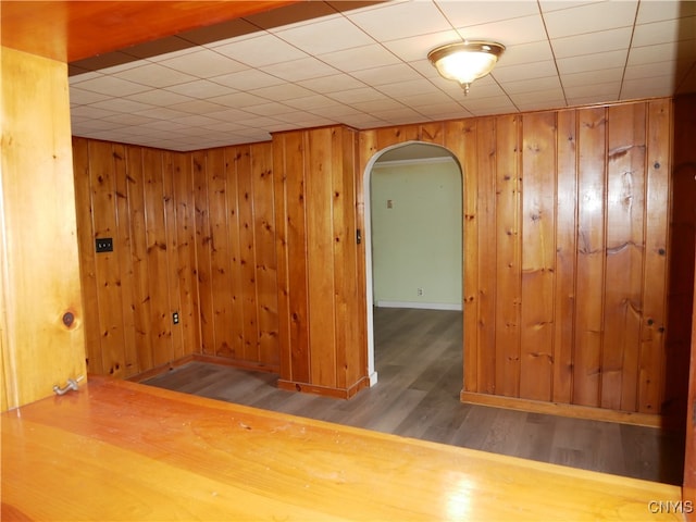 unfurnished room with wooden walls and wood-type flooring