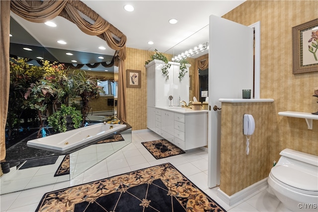 bathroom with tile patterned floors, a washtub, vanity, and toilet