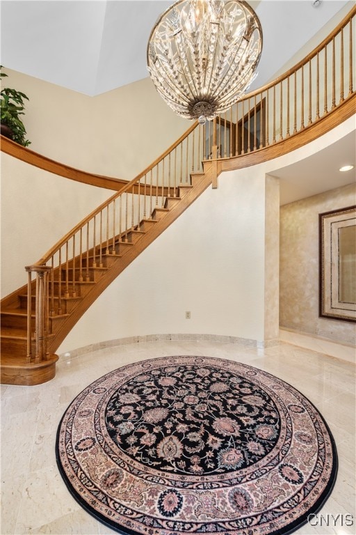 stairway with a towering ceiling and a notable chandelier