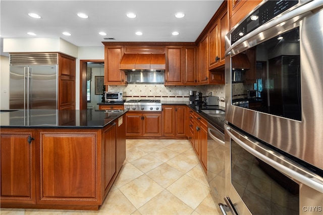 kitchen with custom exhaust hood, backsplash, sink, light tile patterned floors, and appliances with stainless steel finishes