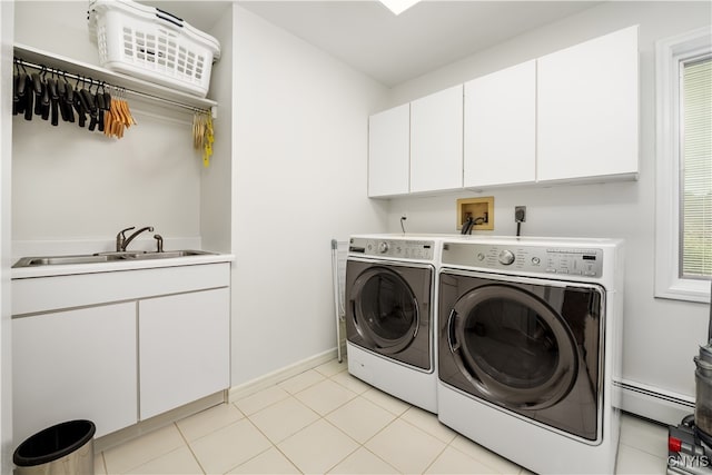 washroom featuring cabinets, sink, a baseboard heating unit, and washing machine and clothes dryer