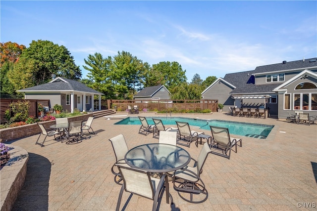 view of pool with a patio area and an outbuilding