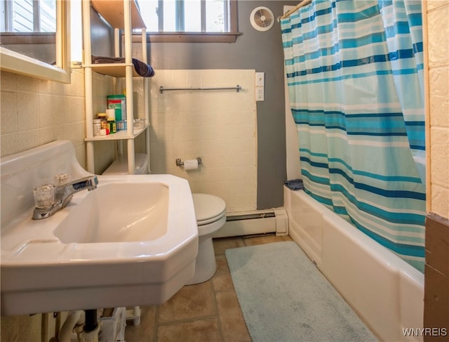 full bathroom with a baseboard heating unit, tile patterned floors, toilet, shower / tub combo with curtain, and tile walls