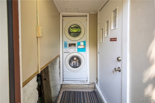 clothes washing area with stacked washing maching and dryer