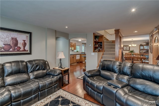 living room with light hardwood / wood-style floors and a notable chandelier