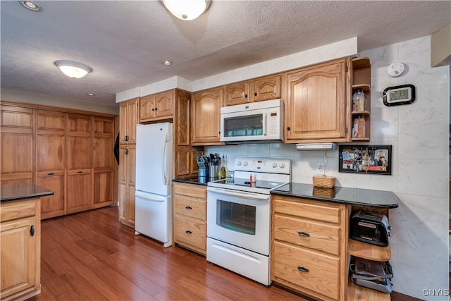 kitchen featuring dark hardwood / wood-style floors, white appliances, and a textured ceiling