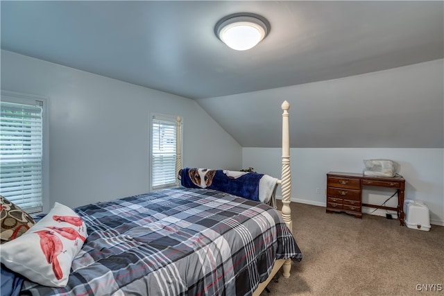 carpeted bedroom with vaulted ceiling and multiple windows