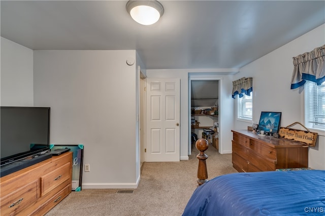 bedroom with light carpet and a closet