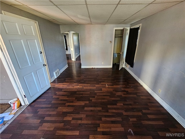 corridor featuring a paneled ceiling and dark hardwood / wood-style floors