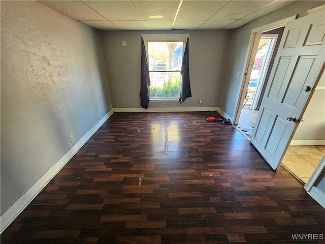 interior space with dark hardwood / wood-style flooring and a drop ceiling