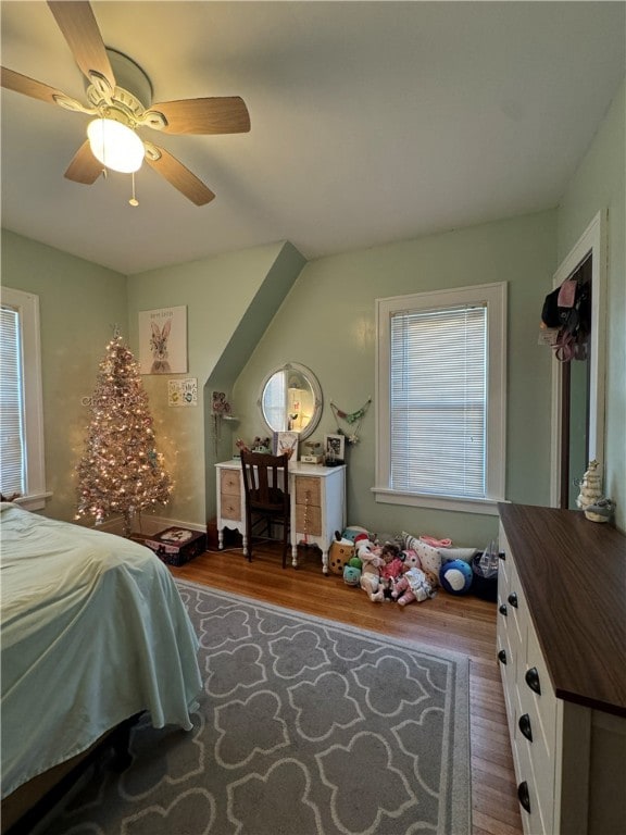 bedroom featuring multiple windows, ceiling fan, and hardwood / wood-style floors