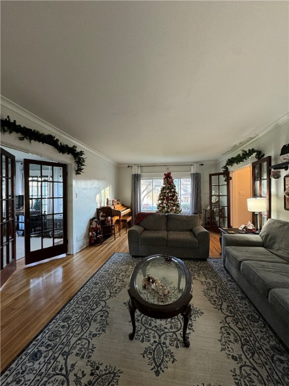 living room with french doors, wood-type flooring, and ornamental molding