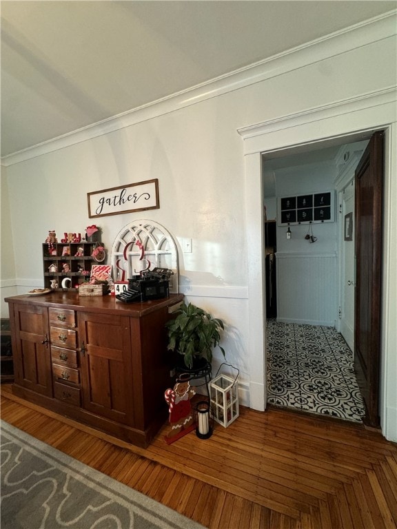 hall with dark wood-type flooring and crown molding