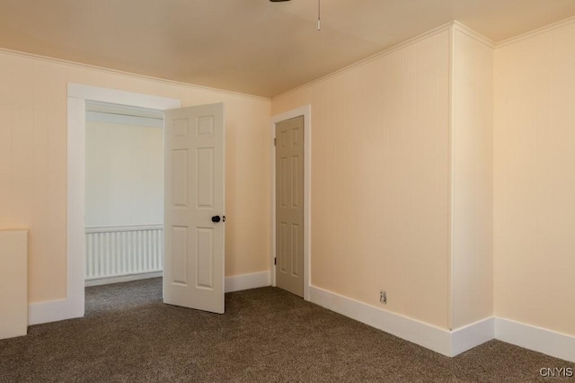 unfurnished bedroom with dark carpet, ornamental molding, and a closet