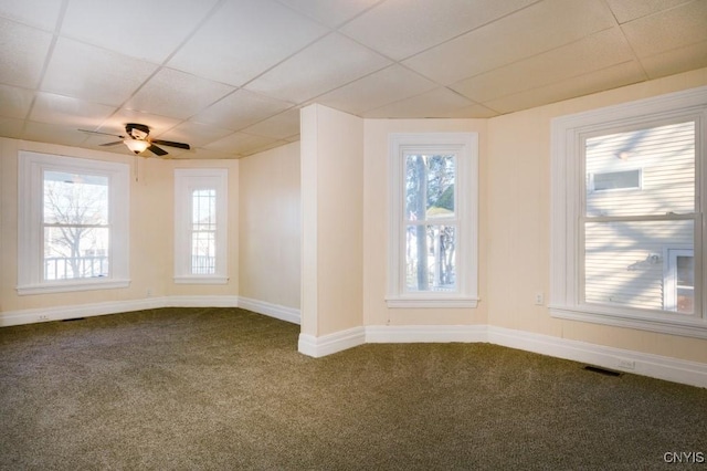 empty room featuring ceiling fan, carpet floors, and a healthy amount of sunlight