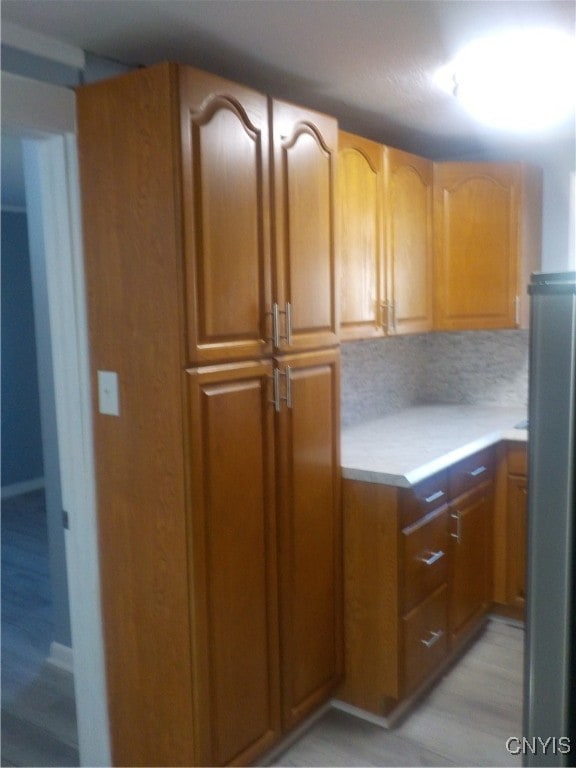 kitchen featuring decorative backsplash and stainless steel refrigerator