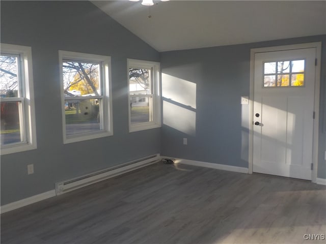 spare room with a healthy amount of sunlight, dark wood-type flooring, vaulted ceiling, and a baseboard heating unit