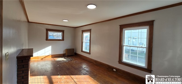 spare room featuring hardwood / wood-style flooring, a healthy amount of sunlight, radiator heating unit, and ornamental molding