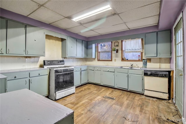 kitchen featuring a paneled ceiling, tasteful backsplash, white appliances, sink, and light hardwood / wood-style floors