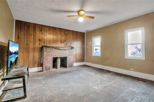 unfurnished living room featuring a fireplace, hardwood / wood-style floors, ceiling fan, and wood walls