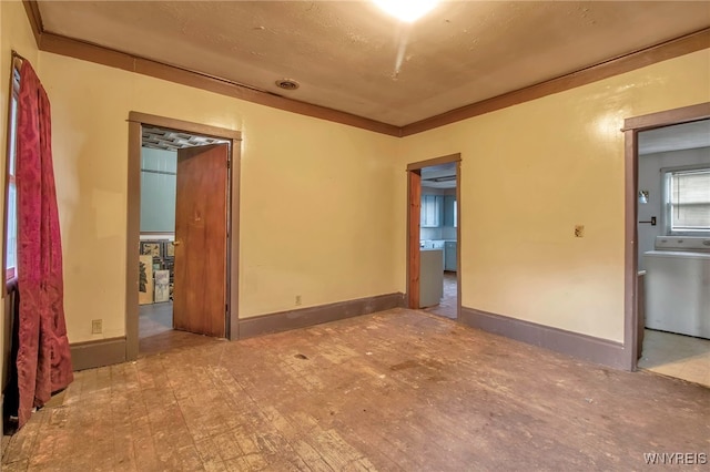 unfurnished room with light hardwood / wood-style floors, crown molding, and washer / clothes dryer