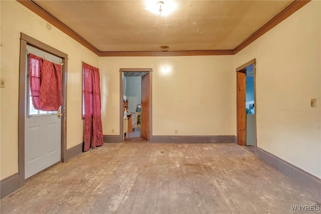 spare room featuring wood-type flooring and ornamental molding