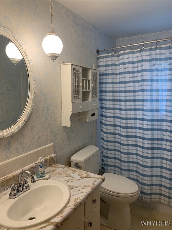 bathroom with tile patterned floors, vanity, curtained shower, and toilet