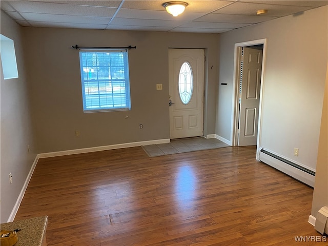 entrance foyer with a drop ceiling, a baseboard radiator, and hardwood / wood-style flooring