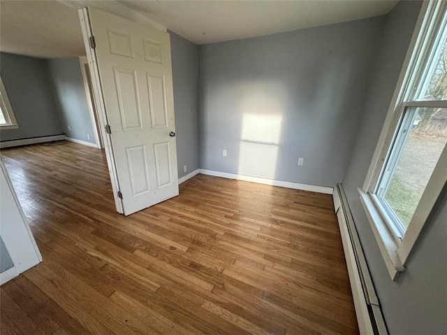 unfurnished bedroom featuring a baseboard radiator and light wood-type flooring