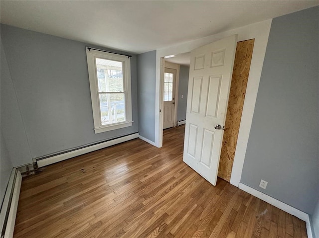 spare room featuring light wood-type flooring and a baseboard heating unit