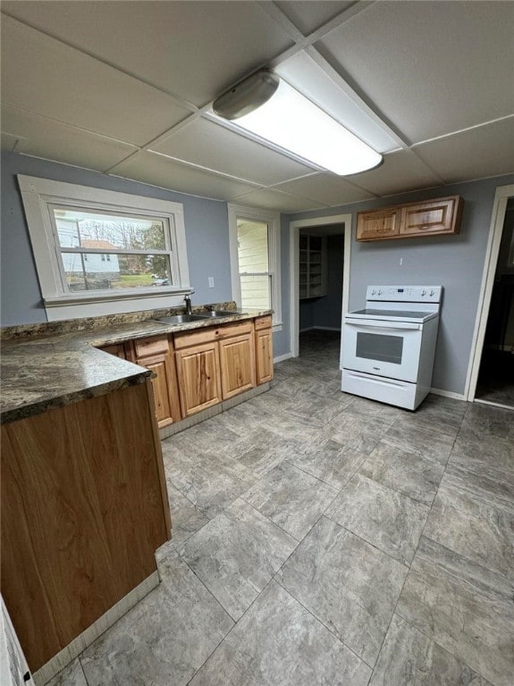 kitchen featuring a paneled ceiling, electric stove, and sink