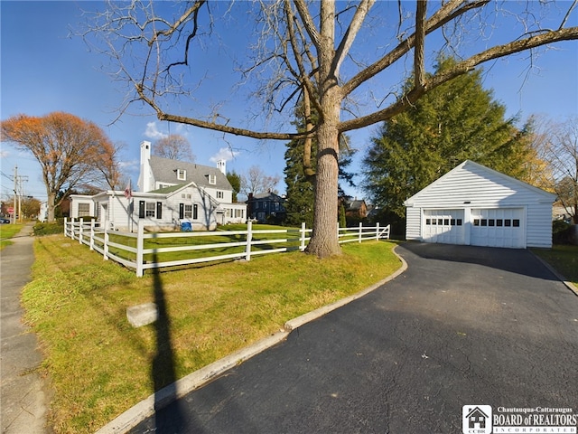 exterior space featuring an outbuilding, a front yard, and a garage