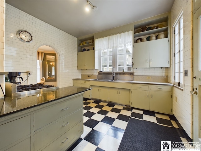 kitchen with tasteful backsplash, sink, and stainless steel gas cooktop