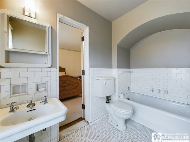 bathroom featuring sink, tile walls, tile patterned flooring, toilet, and a tub