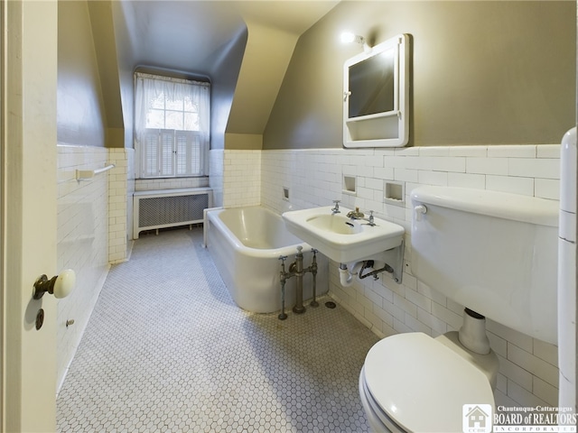 bathroom with toilet, radiator heating unit, tile patterned floors, and tile walls