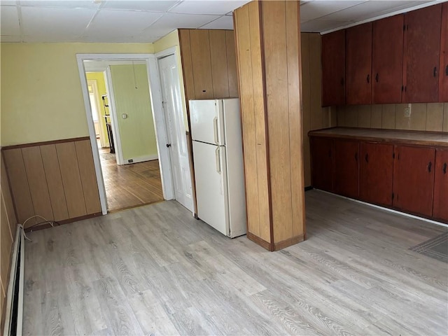 kitchen featuring baseboard heating, a drop ceiling, white fridge, and light wood-type flooring