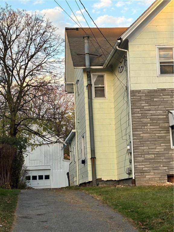 view of side of home featuring a garage and an outdoor structure