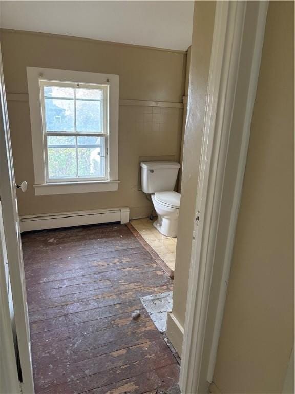 bathroom with wood-type flooring, toilet, and a baseboard heating unit