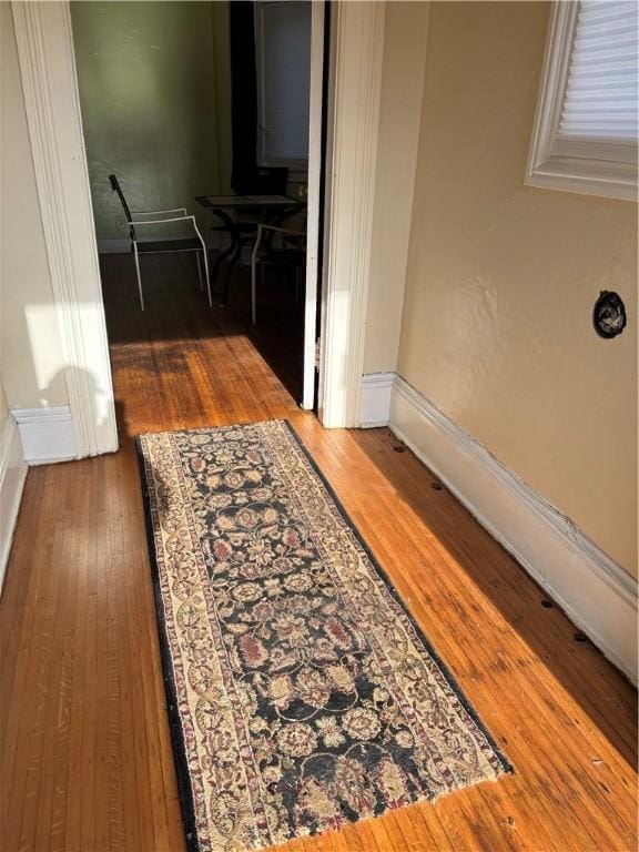 hallway with hardwood / wood-style flooring