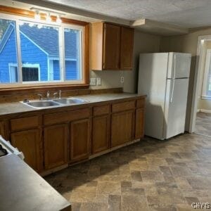 kitchen with a wealth of natural light, sink, and white fridge