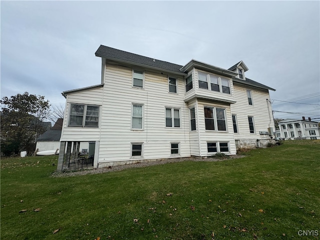 rear view of property featuring a lawn