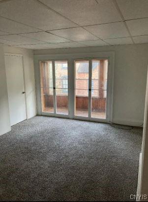 carpeted spare room with a drop ceiling