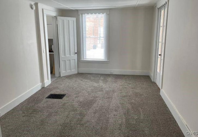 unfurnished bedroom with baseboards, visible vents, and carpet