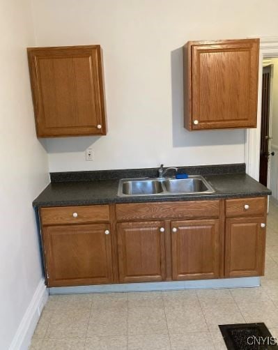 kitchen featuring light tile patterned floors and sink