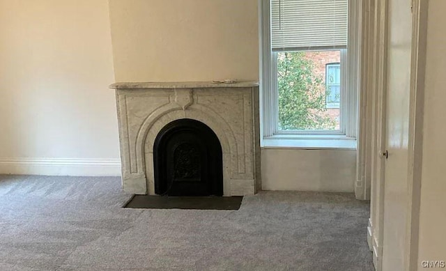 interior details with a fireplace with flush hearth, baseboards, and carpet flooring