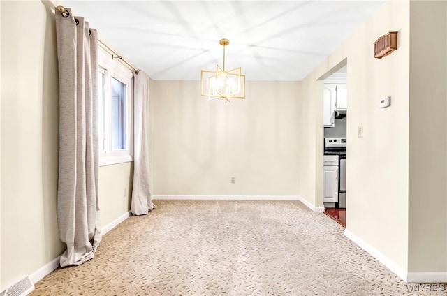 spare room with carpet flooring and an inviting chandelier