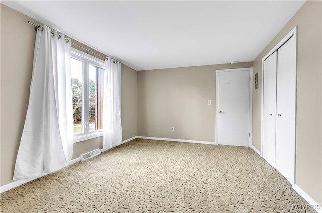 spare room featuring light carpet